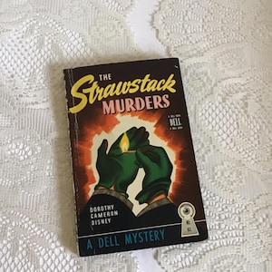 May include: Vintage paperback book titled "The Strawstack Murders" by Dorothy Cameron Disney. The cover features a dramatic illustration of gloved hands lighting a match against a fiery orange and yellow background. A Dell Mystery book.