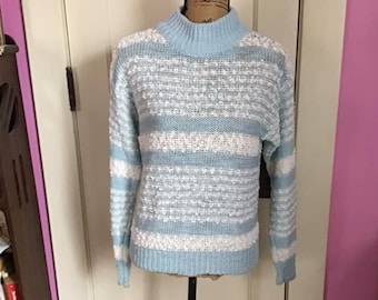 May include: A light blue and white striped sweater with a mock neck. The sweater is made of a soft, fuzzy material.