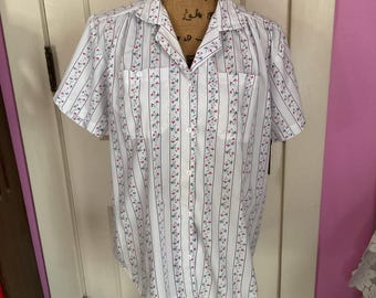 May include: A white short-sleeved button-down shirt with vertical blue and pink stripes and a small floral pattern.