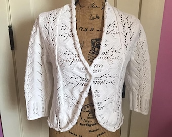 Puede incluir: Chaqueta de punto de ganchillo blanca con un solo botón de cierre y un dobladillo festoneado.