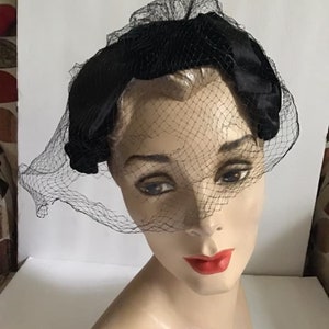 Puede incluir: Una diadema de terciopelo negro con velo de red negro. La diadema se lleva en la cabeza de un maniqu&iacute;.