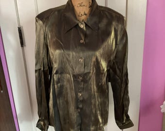 May include: A long-sleeved, button-down shirt in a shimmering olive green color. The shirt has a classic collar and buttoned cuffs. The fabric has a subtle sheen, giving it a luxurious appearance. The shirt is displayed on a mannequin.