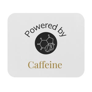 Pode incluir: Base quadrada branca com cantos arredondados. A base apresenta as palavras "Powered by" em preto, com um círculo preto contendo uma molécula de cafeína e grãos de café. A palavra "Caffeine" é dourada.