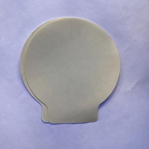 May include: Two white, round, paper baking cups with a scalloped edge.