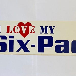 May include: A white bumper sticker with blue and red text that reads "I LOVE MY Six-Pac". A red heart is in the middle of the text "LOVE".