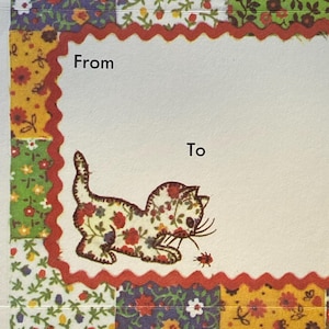 May include: A greeting card with a patchwork design featuring floral patterns in various colors. The card has a white space with the words "From" and "To". A floral patterned cat illustration is on the card.