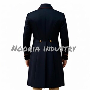 May include: Navy blue long coat with gold buttons and red trim on the collar and cuffs. The coat has a tailored fit and a long, pleated back. The text "NOORIA INDUSTRY" is visible across the bottom of the image.
