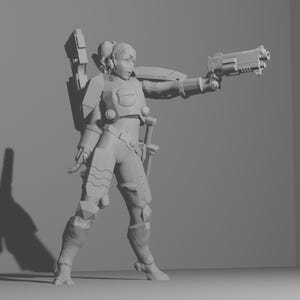 Puede incluir: Una figura de plástico gris de una soldado femenina con armadura y sosteniendo un arma. La figura está de pie sobre una superficie gris.