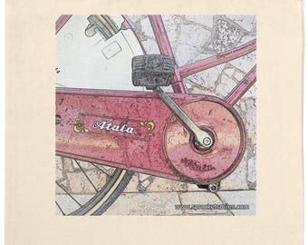May include: A cream tote bag with a pink bicycle design. The bicycle has the word "Atala" on the frame. The bag has long handles and is made of a canvas material, ideal for carrying items.
