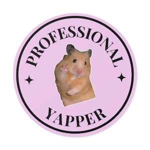 Puede incluir: Una pegatina redonda con fondo rosa claro y texto negro. El texto dice "PROFESSIONAL YAPPER" en un patrón circular. Un hámster está en el centro, saludando. Dos estrellas negras están a cada lado del hámster.