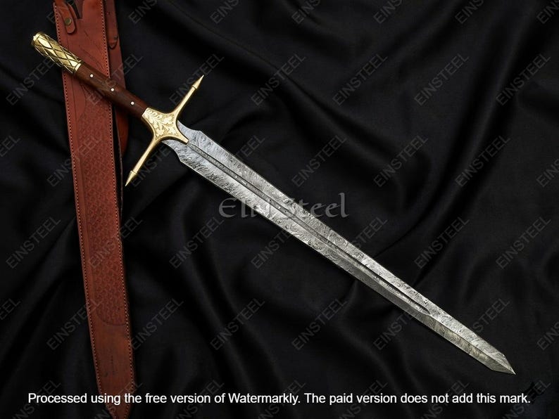 May include: A long, ornate sword with a patterned blade and a gold-colored crossguard and handle. The handle is dark brown, and the sword rests on a black, textured surface. A brown leather sheath is visible.