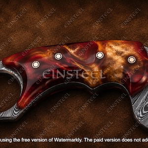 Pu&ograve; includere: Un manico di coltello con un'impugnatura in resina lucida dai motivi rossi e ambrati, fissata da tre rivetti metallici circolari. La lama presenta un distinto motivo in acciaio Damasco grigio e nero con un dettaglio in rame intarsiato.