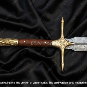 May include: A detailed view of a sword with a wooden handle and a gold-colored crossguard. The blade has a patterned design. The handle is dark brown with a gold-colored end. The sword is displayed on a black background.
