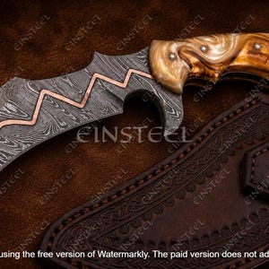 Pu&ograve; includere: Un coltello a lama curva con motivo in acciaio Damasco e un inserto a zigzag in rame lungo il dorso. Il manico &egrave; realizzato in un materiale marmorizzato marrone chiaro con tre rivetti metallici. &Egrave; incluso un fodero in pelle marrone scuro.