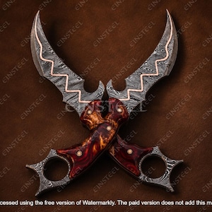 Pu&ograve; includere: Due coltelli karambit incrociati con lame in acciaio Damasco e intarsio in rame ondulato. I manici sono realizzati in legno radica bruno-rossastro lucidato con perni in ottone e anelli per le dita integrati alla base di ogni manico.