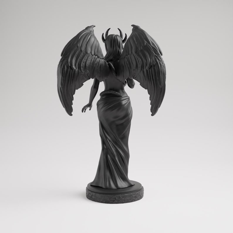 Op de afbeelding: Een zwart beeld van een gevleugelde figuur met hoorns, van achteren gezien. De figuur draagt een vloeiende jurk en staat op een cirkelvormige basis. De vleugels zijn groot en gedetailleerd, in gotische stijl.