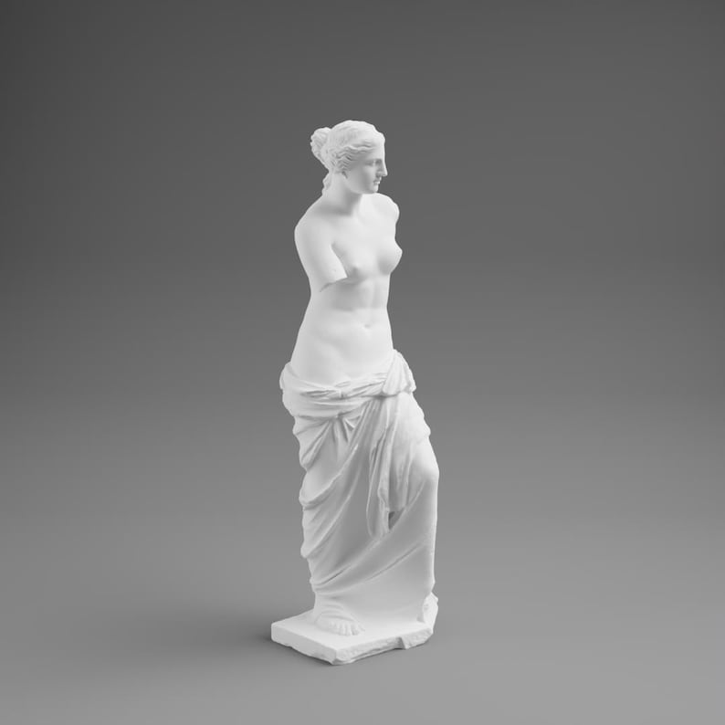 May include: A white statue of Venus de Milo, a classical sculpture. The figure is depicted without arms, draped in fabric, and standing on a rectangular base. The statue is set against a gray background.