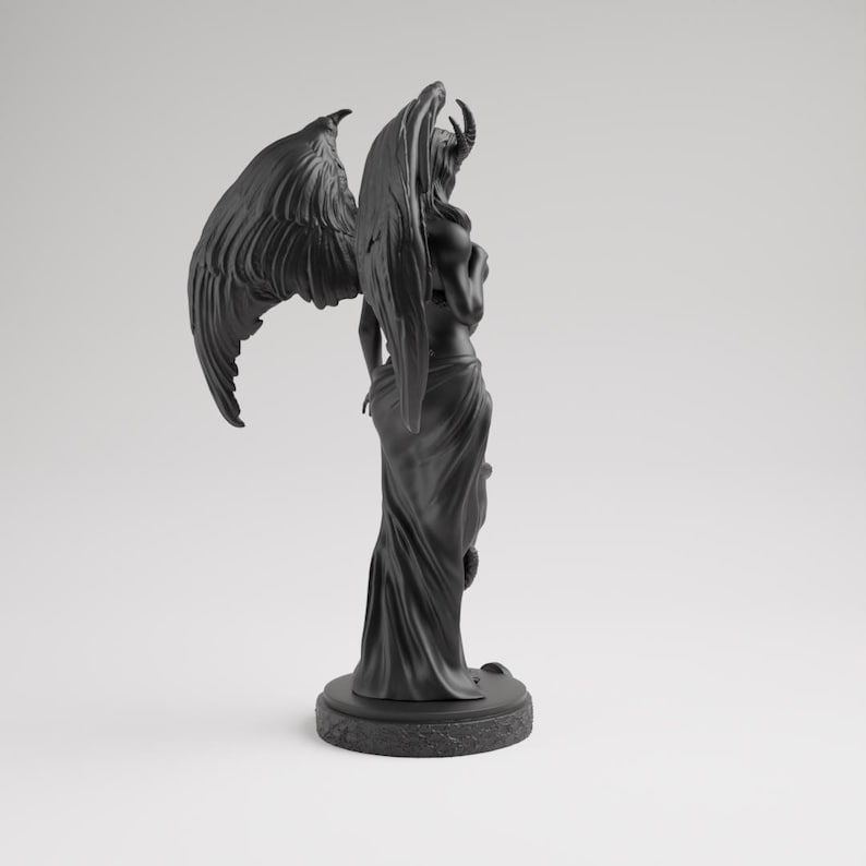 Op de afbeelding: Een zwarte sculptuur van een gevleugelde figuur met hoorns, op een ronde basis. De figuur is gehuld in vloeiende stof, met gedetailleerde vleugels erachter. Het beeld heeft een donkere, matte afwerking.