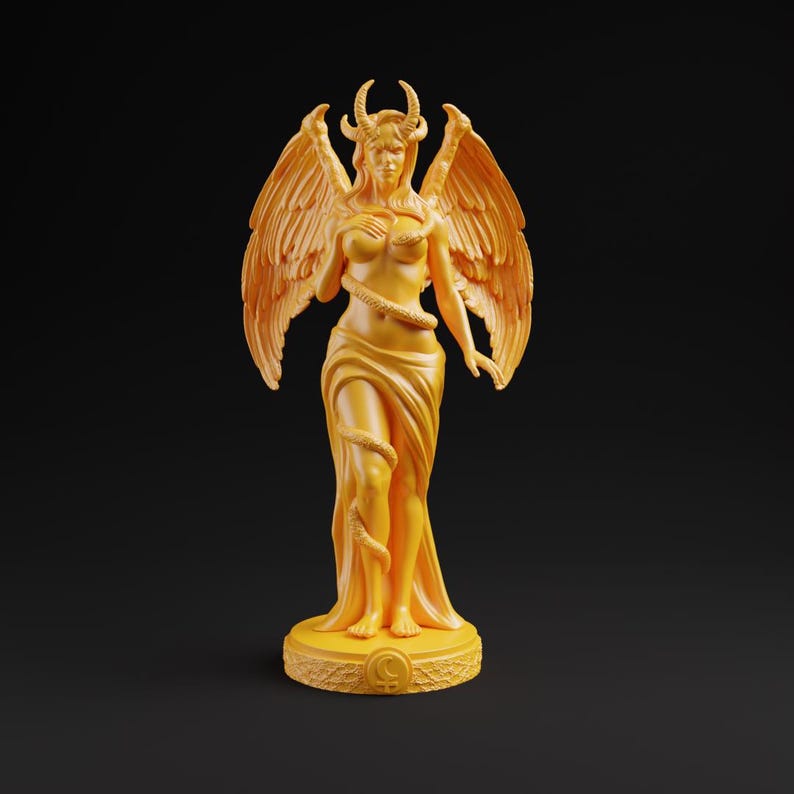 Op de afbeelding: Een gouden beeld van een gevleugelde figuur met hoorns, gehuld in vloeiende stof, en een slang die zich om het lichaam wikkelt. De figuur staat op een cirkelvormige basis met een symbool. Het beeld heeft gedetailleerde vleugels en een serene uitdrukking.