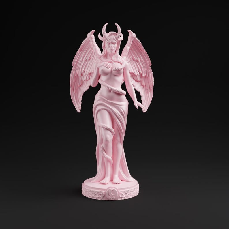 Op de afbeelding: Roze standbeeld van een gevleugelde figuur met hoorns, een slang en een vloeiende jurk. Het beeld staat op een cirkelvormige basis met een maansymbool. De vleugels van de figuur zijn gespreid en een slang is om het lichaam gewikkeld.
