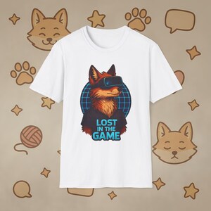 May include: White t-shirt featuring a cartoon fox wearing VR goggles, set against a blue grid. The text "LOST IN THE GAME" is below the fox. The background has fox and paw print illustrations.