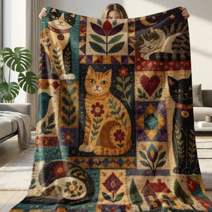 May include: A rectangular throw blanket featuring a patchwork design of various cats, flowers, hearts, and a small house. The cats are depicted in black, white, orange, and tabby patterns, interspersed with colorful floral and geometric motifs.
