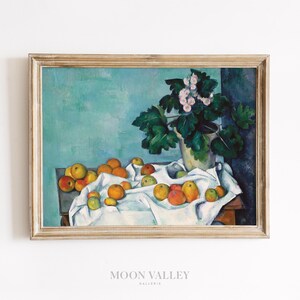 May include: A still life painting of a white tablecloth with a bowl of oranges and apples on a wooden table. A vase with a green plant and pink flowers sits on the table. The background is a teal blue.