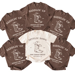 May include: Five brown t-shirts with white text and graphics. The shirts have the text 'Saddlin' Up' and 'Settlin' Down' with a graphic of a cowboy boot and hat. The text 'Jessica's Last Rodeo' and 'Same Cowboy Forever' are also on the shirts.