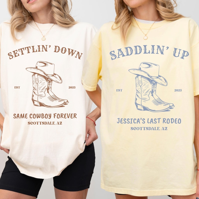 May include: Two short-sleeve crew neck t-shirts. The left shirt is cream with brown text reading SETTLIN' DOWN, SAME COWBOY FOREVER, SCOTTSDALE, AZ, EST 2023, and a cowboy boot and hat graphic. The right shirt is yellow with blue text and graphics.