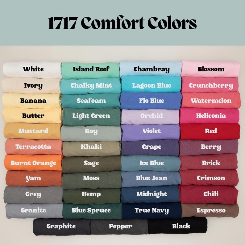 May include: A color chart for 1717 Comfort Colors t-shirts featuring a grid of folded fabric samples. The chart displays various shades including white, ivory, yellow, orange, red, pink, purple, blue, green, grey, brown, and black with labels.