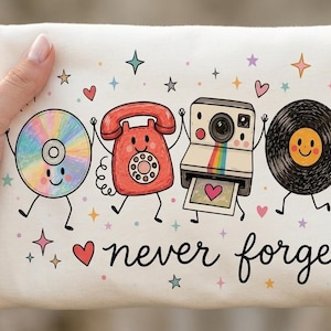 May include: A white fabric pouch featuring a colorful graphic of a CD, a red rotary phone, an instant camera, a vinyl record, and a cassette tape, all with smiling faces. The text "never forget" is printed in black script below the characters.