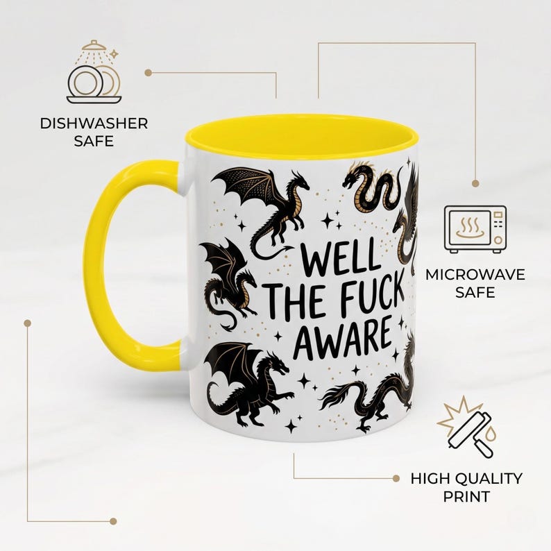 May include: White ceramic mug with a yellow handle and interior. The mug features black dragon illustrations and the text "WELL THE FUCK AWARE". The mug is dishwasher and microwave safe.