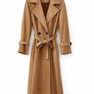 May include: A long, tan trench coat. It features a double-breasted closure, a matching belt, and sleeve straps. The coat has a classic lapel collar and is made of a soft, suede-like material. The coat is a neutral colour and is suitable for various occasions.