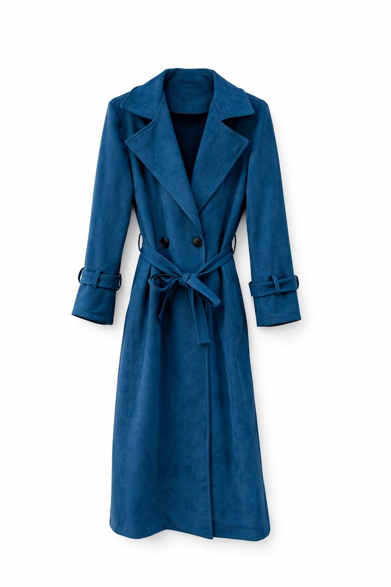 May include: A long, teal blue trench coat with a double-breasted closure and a matching belt. The coat features a notched collar, long sleeves with cuff details, and a knee-length hemline. The coat is made of a soft, textured fabric.