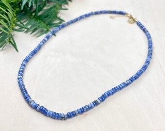 May include: A delicate blue gemstone necklace with a gold clasp. The necklace is made of small, round beads and is perfect for layering.