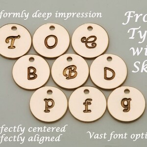 May include: A set of ten round, gold-colored metal discs with various letters engraved on them. The letters are "T", "O", "E", "B", "B", "D", "P", "f", and "g". The text "From Tyra with Skill" is written in cursive script in the upper right corner of the image. The text "* Uniformly deep impression * perfectly centered * perfectly aligned * Vast font options *" is written in cursive script at the top and bottom of the image.