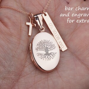 May include: Rose gold necklace with a tree of life locket, a small cross charm, and a bar charm engraved with "05.30.08 XXX". The necklace is on a hand, and the text "bar charm and engraving for extra" is visible above the necklace.