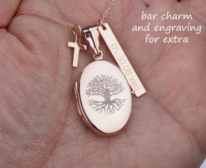 May include: Rose gold necklace with a tree of life locket, a small cross charm, and a bar charm engraved with "05.30.08 XXX". The necklace is on a hand, and the text "bar charm and engraving for extra" is visible above the necklace.