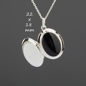 Op de afbeelding: Zilveren ovale ketting met een hanger met een zwarte emaille-inzet. De hanger is 22 x 18 mm.