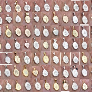 May include: A collection of 48 silver and gold oval locket pendants with various engraved designs. The lockets are on chains and feature designs such as trees, hearts, crosses, stars, and footprints.