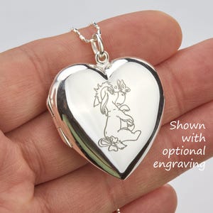 Puede incluir: Medallón de plata en forma de corazón con una imagen grabada de Winnie de Pooh y Piglet. El medallón se muestra con un grabado opcional.