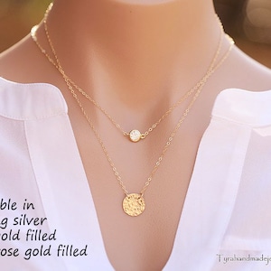 May include: A layered gold necklace with a small round pendant and a larger hammered disc pendant. Available in sterling silver, 14K gold filled, and 14K rose gold filled.