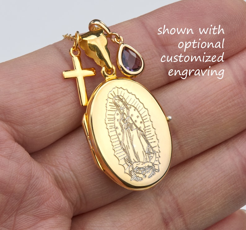 May include: Gold locket necklace with a detailed engraving of the Virgin Mary. The locket has a small cross charm and a purple gemstone charm attached.