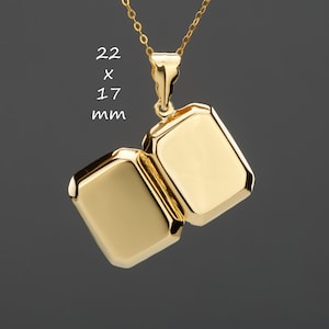 Puede incluir: Un collar de oro con un colgante rectangular en forma de medallón que mide 22 x 17 mm. El medallón está abierto y tiene una superficie lisa y brillante.