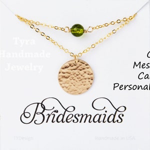 May include: A gold necklace with a hammered circle pendant and a green glass bead. The necklace is displayed on a white card with the text "Tyra Handmade Jewelry" and "Bridesmaids". The card also says "Card Message Can be Personalized".