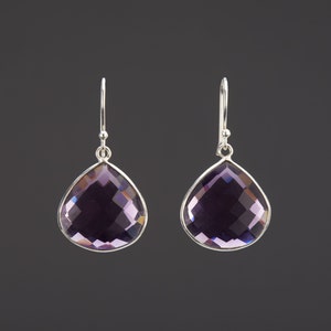 May include: A pair of silver dangle earrings with teardrop-shaped amethyst gemstones.
