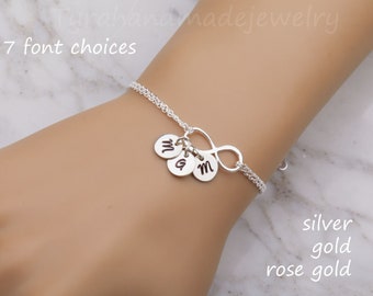 Puede incluir: Pulsera de infinito de plata con tres pequeños colgantes, cada uno grabado con la letra "M". La pulsera está disponible en plata, oro y oro rosa.