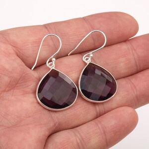 May include: A pair of silver dangle earrings with faceted amethyst teardrop stones.