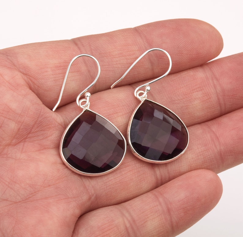 May include: A pair of silver dangle earrings with faceted amethyst teardrop stones.