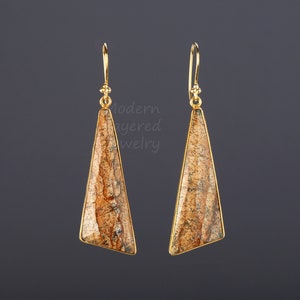 May include: A pair of gold earrings with a triangular shaped stone. The stone is a brown and tan color with a marbled pattern.